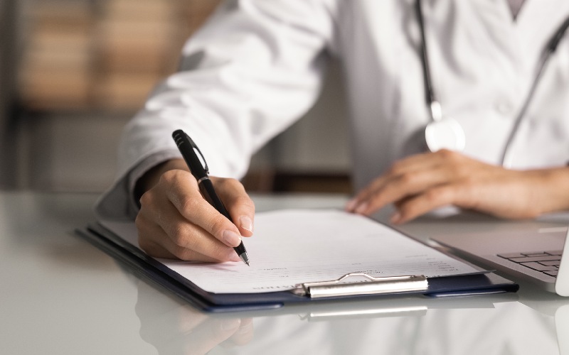 Doctor writing on notebook